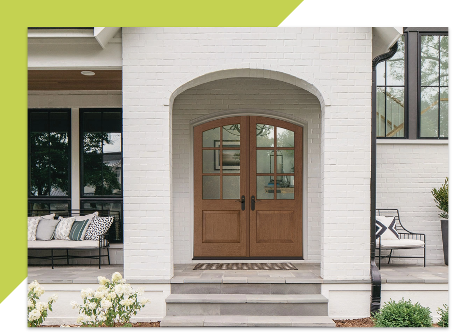 exterior entry of white brick home wood double front doors with glass windows on upper half