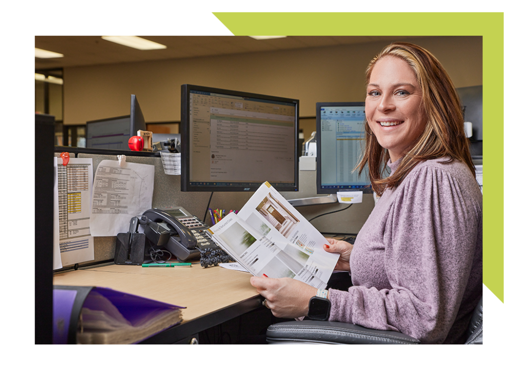 lady sitting at desk working holding a boise cascade flipping book of products